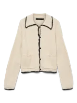 Cardigan tejido color crema con cuello polo, cierre con botones negros y ribete negro con forma de ondas en cuello, cierre, bolsillos y ruedo.