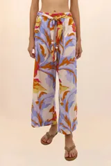 Pantalón de playa de pierna ancha con estampado floral en tonos celeste, naranja, amarillo y fucsia. Presenta cintura elástica y cinturón con cuentas.