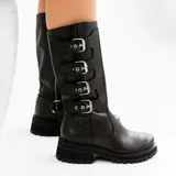 Bota alta de cuero vacuno color negro, con suela de goma artesanal, cierre interno YKK, hebillas ajustables y estribo desmontable.