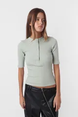 Top camiseta de morley color lila, con mangas cortas y calce slim. Cuello redondo cerrado con cartera de botones snap metálicos en delantero.
