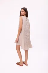 Vestido corto sin mangas de color rojo, con cuello redondo y detalle de abertura tipo gota en el pecho. Presenta un diseño holgado y terminación con volado en el ruedo.