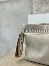 Sobre de mano plateado con detalles en yute y pulsera personalizada con la palabra "RUPIA".