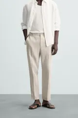 Pantalón de vestir color beige claro, de corte recto, confeccionado en lino.
