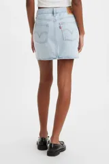 Falda corta de denim color celeste claro, con cierre frontal de botones y talle medio. Presenta un diseño asimétrico con un corte en el ruedo lateral.