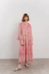 Vestido largo azul con estampado floral en tonos beige, confeccionado en viscosa. Presenta escote en V, botonadura completa en el frente y mangas largas con volados.