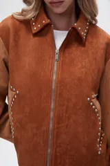 Chaqueta corta color marrón con detalles en color camel, de gamuza sintética, con cuello camisero, cierre frontal con cremallera y apliques de tachas plateadas.