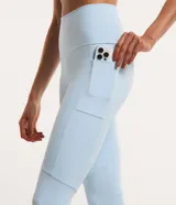 Conjunto deportivo celeste compuesto por un top con tirantes finos y calzas largas con cintura alta y recortes en las rodillas.