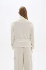 Campera negra de poliéster con cierre frontal, cuello alto, bolsillos con solapa en el pecho y cintura ajustable con cordón.