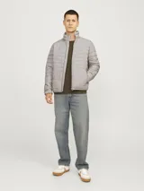 Campera puffer gris de manga larga con cuello alto y cierre frontal con cremallera.