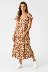 Vestido midi de viscosa con estampado de hojas en tonos beige y marrón, corte ancho, cuello en V y mangas cortas con volados.