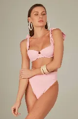 Conjunto de bikini rosa con corpiño con aro y breteles con lazos, y bombacha de tiro alto.