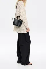 Bolso tote pequeño color visón de piel granulada con doble asa corta y correa bandolera ajustable y extraíble. Incluye bolsa interior ajustable con cordones. Logotipo de la marca grabado en el frente.