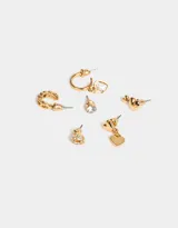 Set de seis aros dorados con diferentes diseños: aros tipo botón con forma de corazón con strass, aro tipo botón con strass, aro tipo botón con dos corazones, aro tipo argolla con tres corazones, aro tipo argolla con dije de corazón con strass y aro tipo botón con dije de corazón.