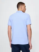Remera polo blanca de piqué de algodón, con cuello clásico, tapeta de dos botones y logo de oso bordado en el pecho.