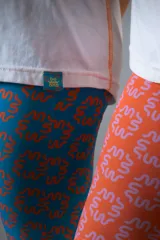 Calza tipo oxford confeccionada en lycra de malla estampada con motivos geométricos en color naranja y lila.