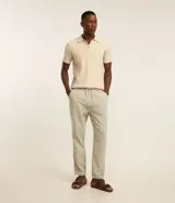 Pantalón relaxed de hombre confeccionado en tejido oxford de algodón color beige, con trabillas en la cintura y cordón para lazo.