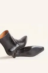 Botín blanco con estampado de piel de serpiente, punta fina y taco chupete. Cierre con cremallera en la parte trasera.