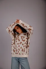 Sweater de punto color crudo con estampado animal print marrón.