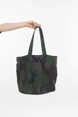 Bolso tipo tote bag con estampado de camuflaje y logo bordado.