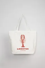 Bolso tipo tote bag de tela color crudo con estampa de una langosta roja y texto "Lobster The Sea Capsule".