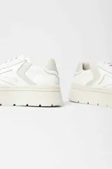 Zapatillas urbanas blancas con suela de plataforma track y detalle de pespuntes.