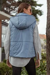 Chaleco puffer negro con capucha, dos bolsillos frontales y cierre con botones.