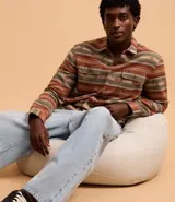 Camisa de hombre de manga larga con cuello inglés y cierre abotonado. Presenta bolsillos delanteros y un estampado étnico con jacquard.