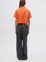 Camisa crop verde con estampado abstracto en tonos naranja y celeste, de mangas cortas y cuello camisero. Confeccionada en viscosa.