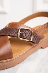 Sandalias marrones con tiras cruzadas de cuero liso y cuero con textura de reptil.