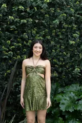 Vestido corto de fiesta color verde oliva con lentejuelas, escote halter con argolla dorada y espalda descubierta.