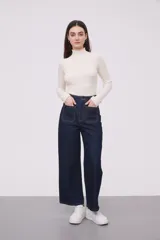 Pantalón de jean azul oscuro, de corte recto y tiro alto, con bolsillos delanteros y traseros de parche.