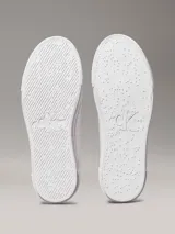 Zapatillas urbanas Calvin Klein Jeans de cuero sintético color blanco, con plataforma plana, cordones y logo CK en el lateral.