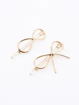 Set de dos broches dorados para el pelo: uno con forma de moño y otro con forma de infinito.