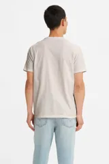 Remera de manga corta color beige con estampado ovalado en el frente con el logo de Levi's en azul y rojo.