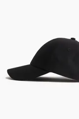 Gorra deportiva negra de tejido funcional repelente al agua, con cinta antitranspirante y hebilla metálica ajustable en la parte posterior.
