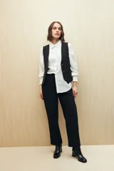 Pantalón negro de corte recto con bolsillos laterales y cintura elástica.