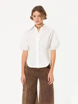 Camisa negra de popelina, de silueta amplia y diseño liviano. Incluye cuello clásico y cierre frontal con botones.