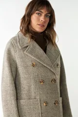 Abrigo de lana color beige con cuello solapa y manga larga. Cierre frontal cruzado doble con botones dorados. Bolsillos delanteros plaqué y forro al tono. Tela 100% lana fina sin teñir, diseñada exclusivamente por Don Baez. Hecho 100% en Uruguay.