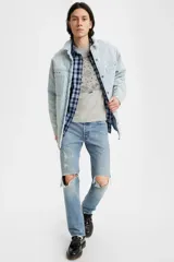 Jeans de corte recto en azul claro, con desgastes y roturas en las rodillas, tiro medio y regular.