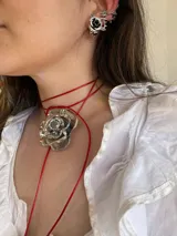 Gargantilla con cordón rojo ajustable y dije de rosa plateada.