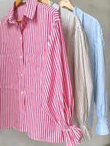 Camisa de mangas largas abullonadas, con puños elásticos y estampado a rayas verticales rojas y blancas.