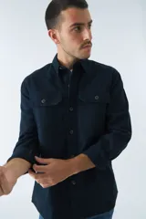 Sobrecamisa azul marino de twill de algodón con cuello clásico, cierre frontal con botones a tono, dos bolsillos de parche con solapa abotonada en el pecho, mangas largas con puños abotonados y corte regular.