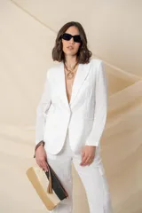 Blazer blanco de lino, corte clásico, con solapas de muesca, cierre frontal con un botón forrado y bolsillos ojal.