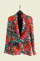 Blazer clásico con estampado floral y animal print, corte entallado y largo hasta la cadera. Tiene hombreras y forro de satén con diseño de la marca.