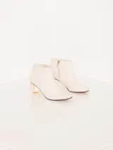 Bota de caña baja en cuero vacuno, con taco de acrílico y costuras artesanales en el empeine.