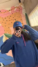 Gorro azul con visera, con la letra K bordada en blanco en el frente y ajuste trasero con hebilla metálica.
