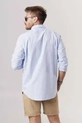 Camisa de hombre color crema, de corte clásico, con cuello abotonado y mangas largas.