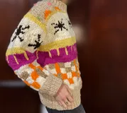 Sweater de lana merino con cuello redondo y diseño con motivos geométricos en tonos azul, marrón, naranja, verde y beige.