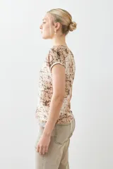 Blusa beige con estampado animal print, escote en V y mangas cortas.