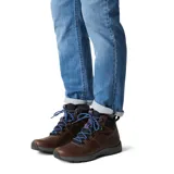 Bota de senderismo de cuero marrón con cuello acolchado negro, cordones azules y suela gris.